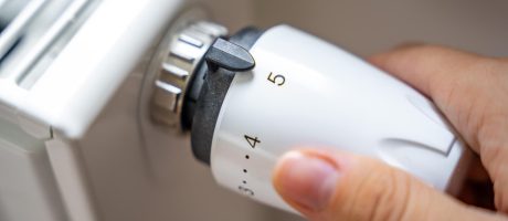 Topenář při montáži radiátoru v bytě