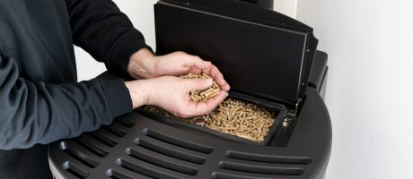 Detail rukou s peletami nad zásobníkem kotle – ukázka provozu a obsluhy kotle na pelety při rozhodování o výměně vytápění